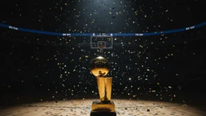 Golden NBA championship trophy on hardwood with confetti, representing the best basketball players of all time