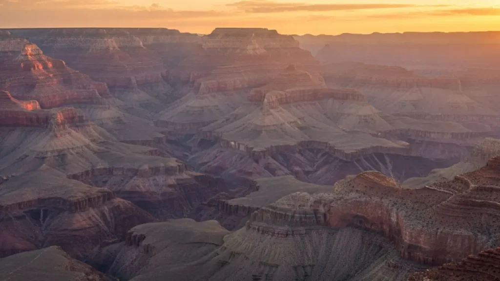 Grand Canyon South Rim at sunset with dramatic clouds and golden light, one of the best places to visit in the US