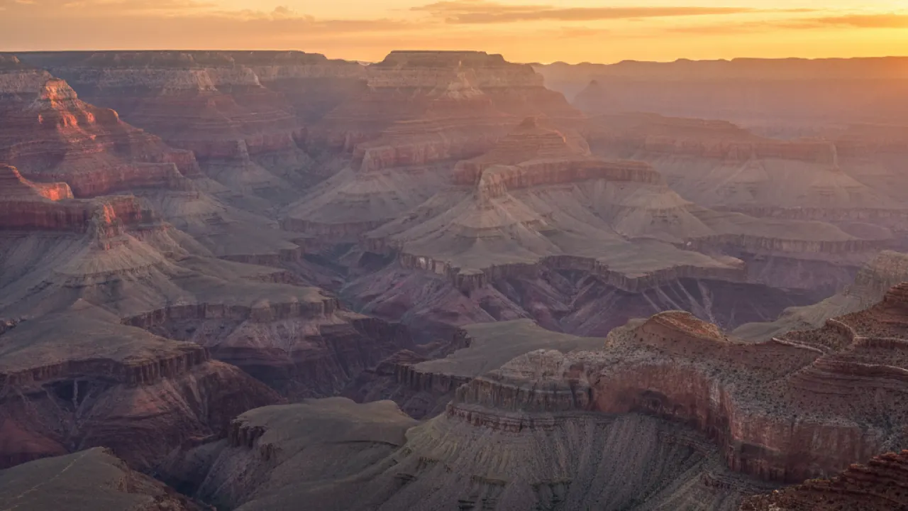 Grand Canyon South Rim at sunset with dramatic clouds and golden light, one of the best places to visit in the US