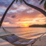 Stunning tropical beach at sunset with palm trees white sand turquoise water and colorful sky with hammock representing best beach destinations 2026